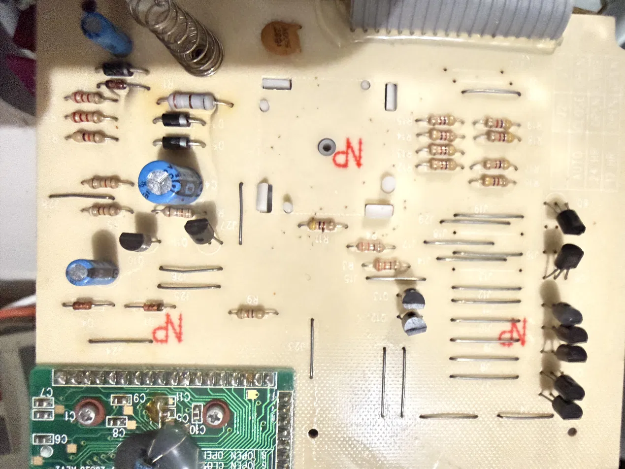 Logic board, component side: rows of small transistors, resistors, wire jumpers and red NP marks, with the COB daughtercard at one corner